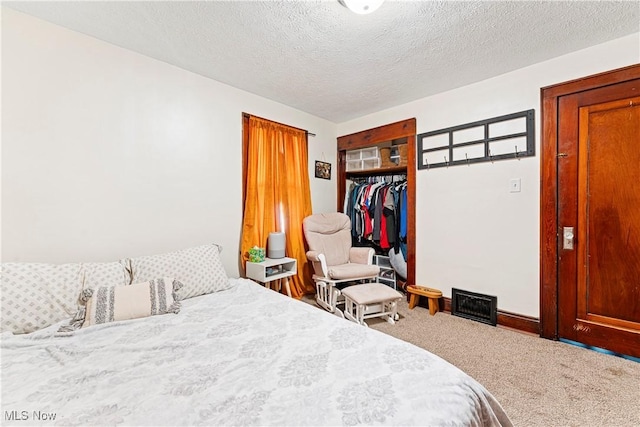 carpeted bedroom with baseboards, a closet, and a textured ceiling