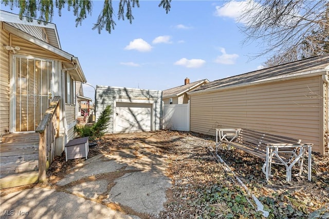 view of yard featuring aphalt driveway, an outdoor structure, and fence