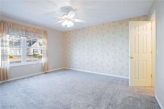 unfurnished room with baseboards, ceiling fan, and carpet flooring