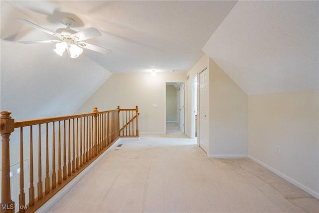 additional living space with baseboards, carpet floors, ceiling fan, and vaulted ceiling