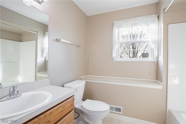 bathroom featuring vanity, toilet, visible vents, and walk in shower