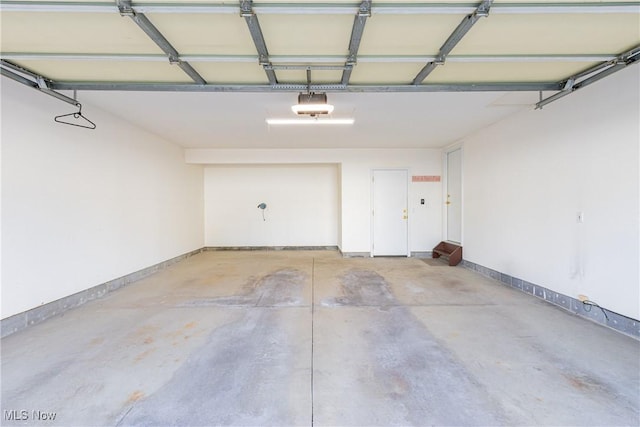 garage with a garage door opener and baseboards