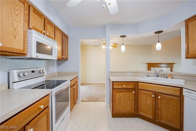 kitchen with white appliances, brown cabinetry, a ceiling fan, light floors, and a sink