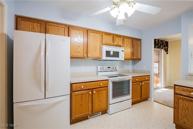 kitchen with white appliances, a ceiling fan, brown cabinetry, visible vents, and light countertops