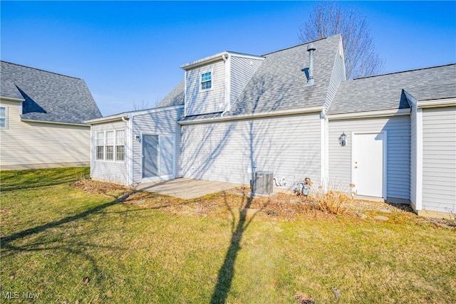 back of property with cooling unit, a lawn, and roof with shingles