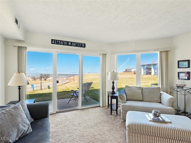 carpeted living room featuring visible vents and a textured ceiling