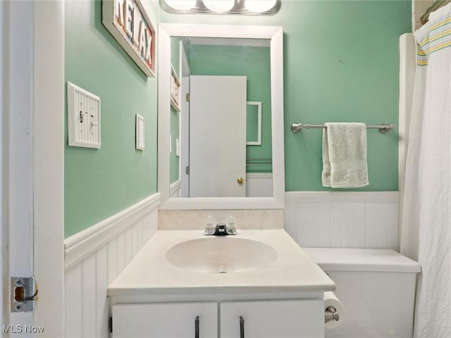 bathroom featuring wainscoting, vanity, and toilet