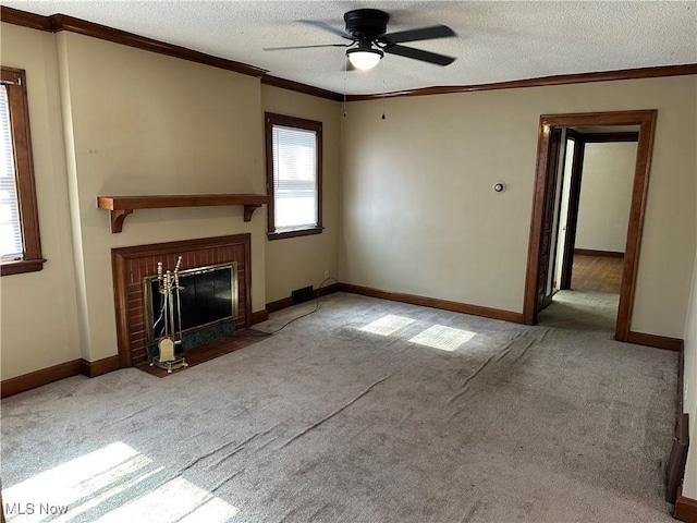 unfurnished living room with a fireplace with flush hearth, a textured ceiling, crown molding, and carpet