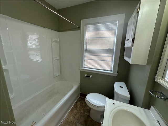 bathroom with toilet, tub / shower combination, and baseboards