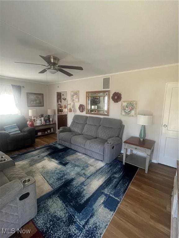 living room with visible vents, ornamental molding, a ceiling fan, and wood finished floors