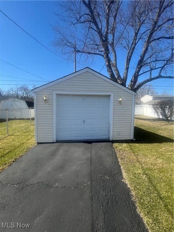 detached garage with driveway and fence