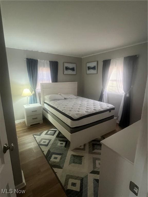 bedroom with wood finished floors and baseboards