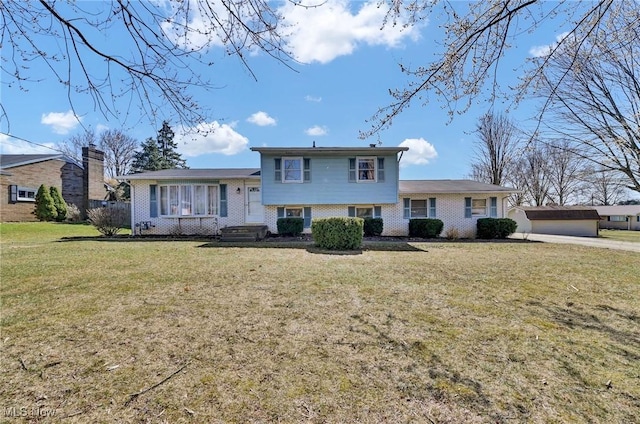 split level home with a front yard and brick siding