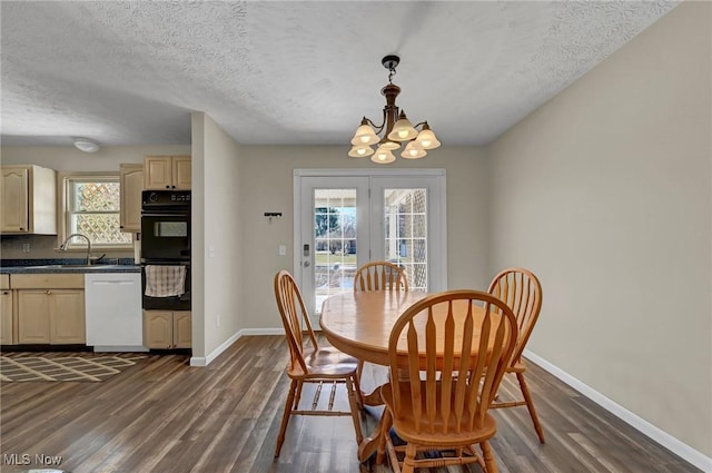 dining room with a textured ceiling, baseboards, an inviting chandelier, and dark wood-style flooring