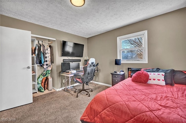 carpeted bedroom featuring baseboards and a textured ceiling