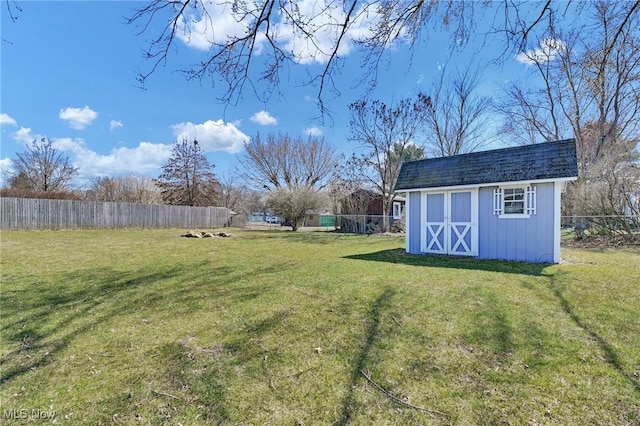 view of yard with a storage unit, an outbuilding, and a fenced backyard