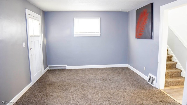 spare room with visible vents, stairway, baseboards, and carpet floors