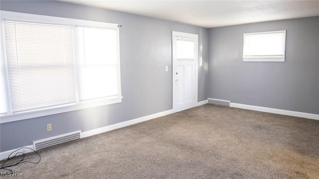 carpeted empty room with visible vents and baseboards