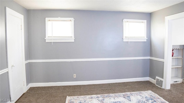 carpeted empty room featuring baseboards