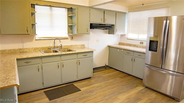 kitchen with light wood-style flooring, a sink, open shelves, under cabinet range hood, and stainless steel fridge with ice dispenser