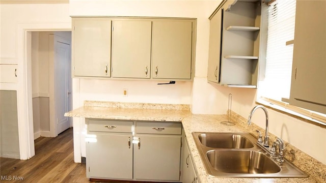 kitchen featuring a sink, open shelves, and wood finished floors