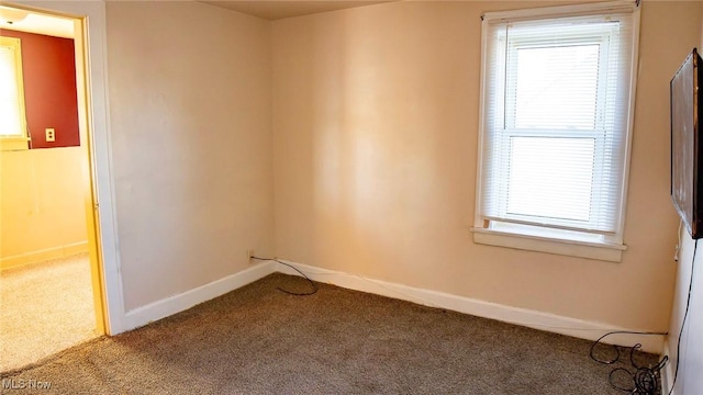 carpeted empty room with baseboards