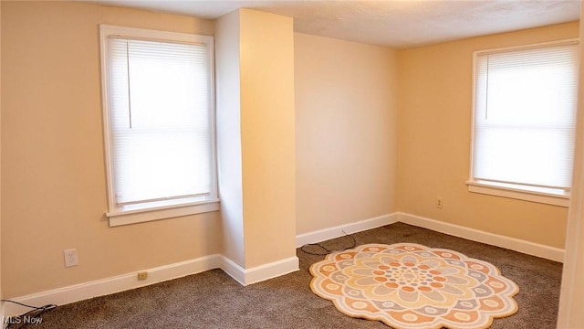 unfurnished room with carpet, a healthy amount of sunlight, and baseboards