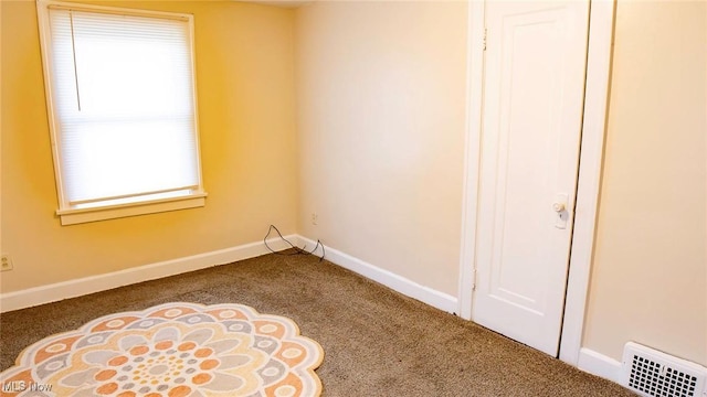 empty room with visible vents, carpet floors, and baseboards