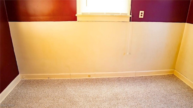 basement featuring baseboards and carpet flooring