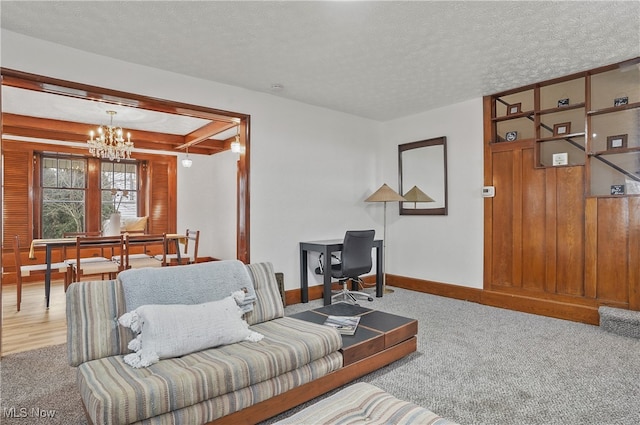 living area with baseboards, a textured ceiling, an inviting chandelier, and carpet floors