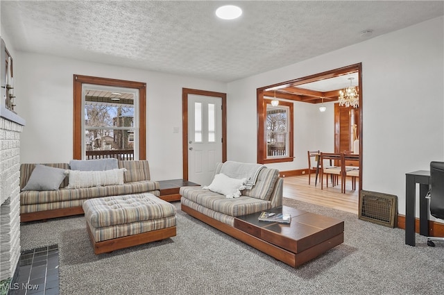 living area featuring an inviting chandelier, plenty of natural light, and a textured ceiling