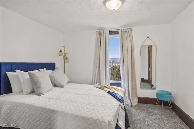 carpeted bedroom with baseboards and a textured ceiling