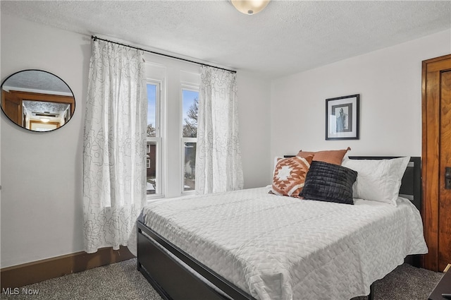 bedroom with a textured ceiling and baseboards