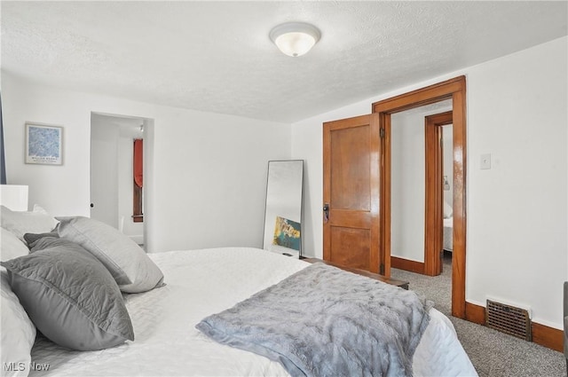 carpeted bedroom with baseboards, visible vents, and a textured ceiling