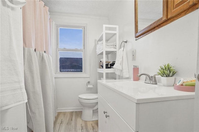 full bath with baseboards, toilet, vanity, wood finished floors, and a textured ceiling