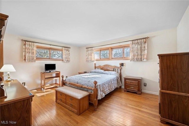 bedroom featuring baseboards and light wood finished floors