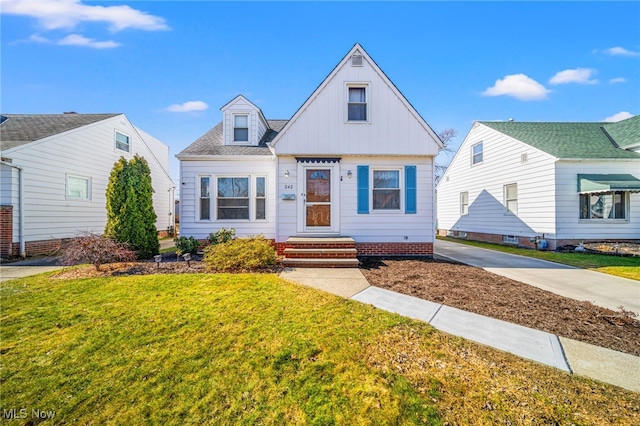 view of front of house featuring a front yard and a shingled roof