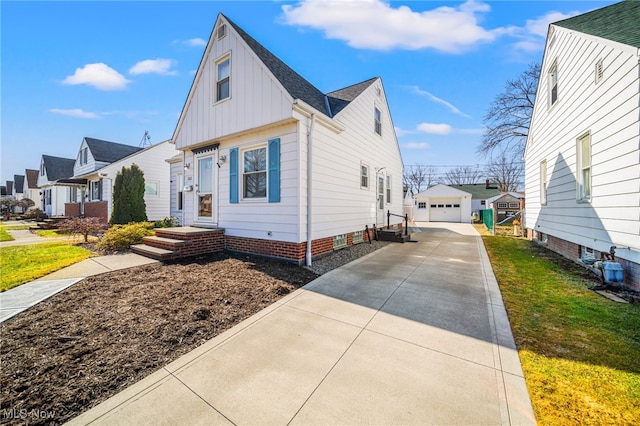 view of property exterior featuring an outbuilding, board and batten siding, concrete driveway, and a detached garage