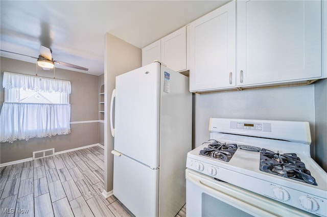 kitchen featuring white appliances, a ceiling fan, visible vents, baseboards, and white cabinetry