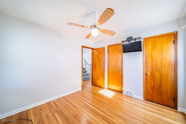 unfurnished bedroom with visible vents, light wood-style flooring, a closet, baseboards, and ceiling fan