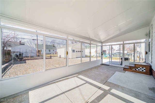 unfurnished sunroom featuring a residential view and vaulted ceiling