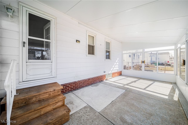 unfurnished sunroom featuring lofted ceiling