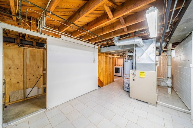 unfinished basement with gas water heater, concrete block wall, heating unit, and washer / dryer