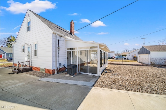 back of property featuring fence, cooling unit, a chimney, a sunroom, and crawl space