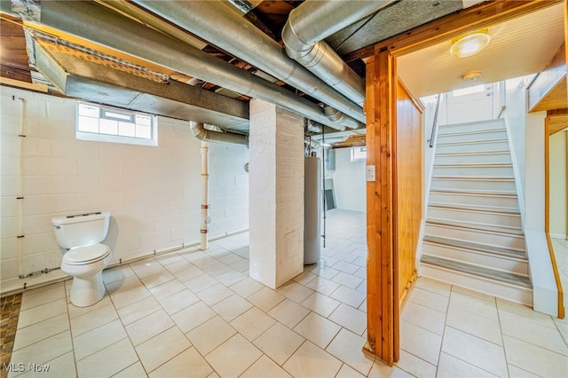 basement with light tile patterned floors, stairway, and gas water heater