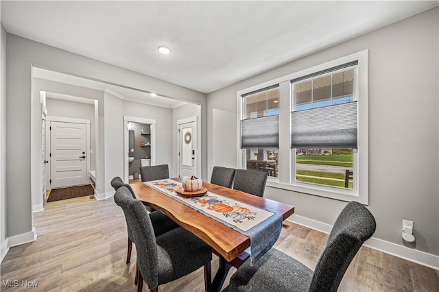 dining area with light wood-style floors and baseboards