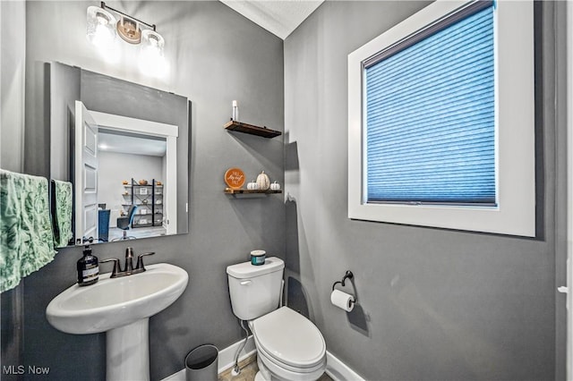 bathroom with baseboards and toilet