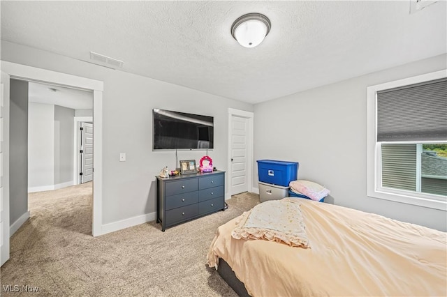 carpeted bedroom featuring visible vents, a textured ceiling, and baseboards