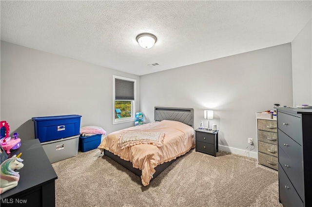 bedroom with baseboards, visible vents, a textured ceiling, and carpet