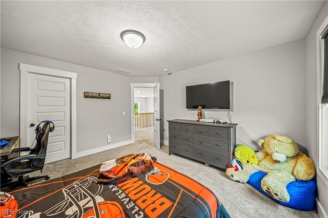 bedroom featuring carpet, baseboards, and a textured ceiling